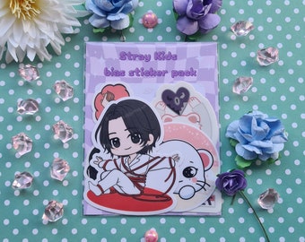 Puede incluir: Un paquete de pegatinas con una ilustración de dibujos animados de un ídolo del K-pop sobre un fondo rosa. El texto "Stray Kids bias sticker pack" está impreso en la parte delantera del paquete.