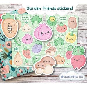 May include: A sheet of colorful, illustrated stickers featuring various garden vegetables with cute, smiling faces. The stickers include a carrot with a bunny, garlic, eggplant, and mushrooms. Text reads "Garden friends stickers!"