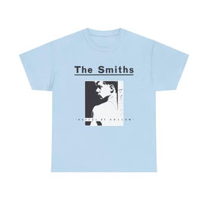 May include: Light blue t-shirt with a black and white image of a man's face and the text "The Smiths" and "Hatful of Hollow".