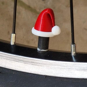 May include: A red and white Santa hat valve stem cap for a bicycle tire.
