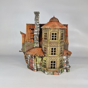 A painted miniature of a two-story fantasy building with a red-orange tiled roof, stone foundation, and wooden walls, viewed from the right side, showing a multi-level turret.