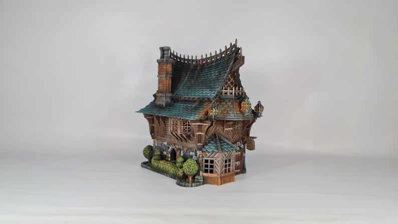 May include: A detailed miniature house with a teal roof, brick chimney, and wooden siding. The model features intricate architectural details, including small windows, decorative trim, and a small garden with bushes. The overall color palette is earthy with hints of teal and brown.