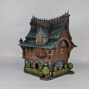 May include: A detailed miniature fantasy house with a green roof, wooden accents, and stone base. The house features intricate architectural details, including decorative trim, windows, and a small garden. The overall design evokes a whimsical, storybook aesthetic.