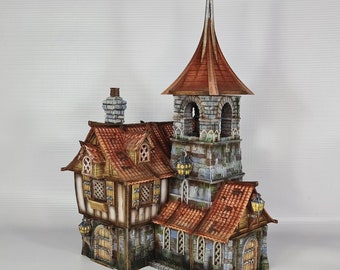 Könnte beinhalten: Ein Miniaturmodell eines mittelalterlichen Gebäudes mit einem hohen Turm und einem kleineren angebauten Gebäude. Der Turm hat ein spitzes Dach und einen Glockenturm. Das kleinere Gebäude hat ein Giebeldach und Fenster. Das Modell ist aus bemaltem Papier gefertigt und mit Steinwerk und Fenstern detailliert.