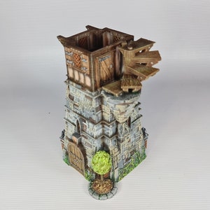 May include: A miniature stone tower with a wooden roof and a small wooden door. The tower has a wooden walkway and a small tree in front of it.