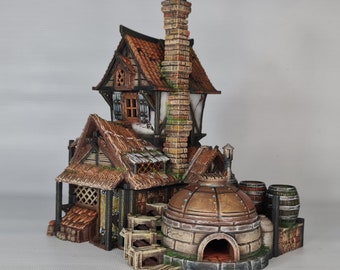 Può includere: Un modello in miniatura di un edificio in mattoni con un tetto di paglia e un grande camino in mattoni. L'edificio ha un grande forno rotondo in mattoni con una porta in metallo. Il modello è dipinto in tonalità di marrone, verde e grigio.