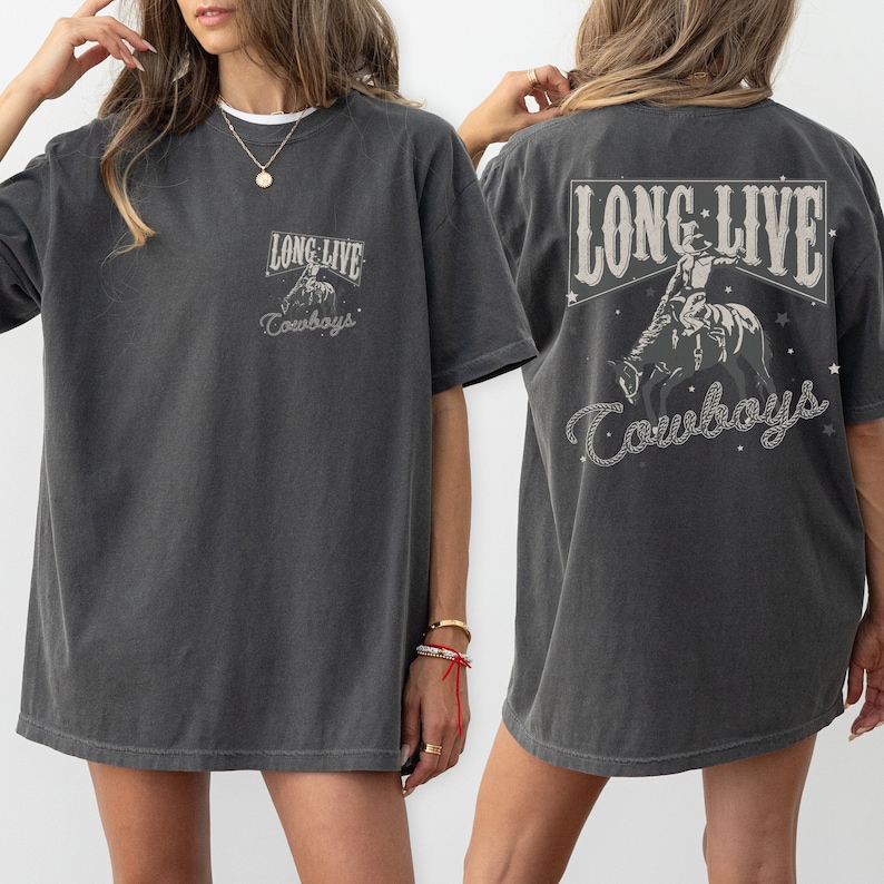 May include: Dark gray t-shirt with the text "LONG LIVE Cowboys" in a Western-style font. The front of the shirt features a small graphic, while the back displays a larger design of a cowboy riding a horse.