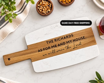 Puede incluir: Una tabla de servir rectangular con una superficie de mármol blanco y una franja horizontal central de madera marrón. La sección de madera tiene grabado el texto: THE RICHARDS AS FOR ME AND MY HOUSE, we will serve the Lord.