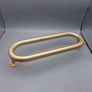 May include: A gold-colored oval-shaped door handle with a round base.