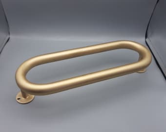 May include: A gold-colored oval-shaped door handle with a round base.