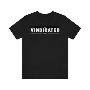 May include: Black t-shirt with the text "VINDICATED" in white with two stars above and below the text.
