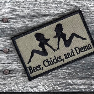May include: A green and black embroidered patch with two black silhouettes of women and the text "Beer, Chicks, and Demo".