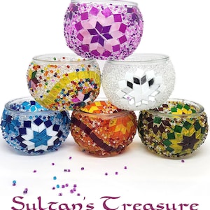 May include: A collection of six colorful, mosaic-style tealight holders. The holders feature various designs and colors, including purple, white, blue, orange, and green. The text "Sultan's Treasure DIY Tealight Craft Kits" is at the bottom.