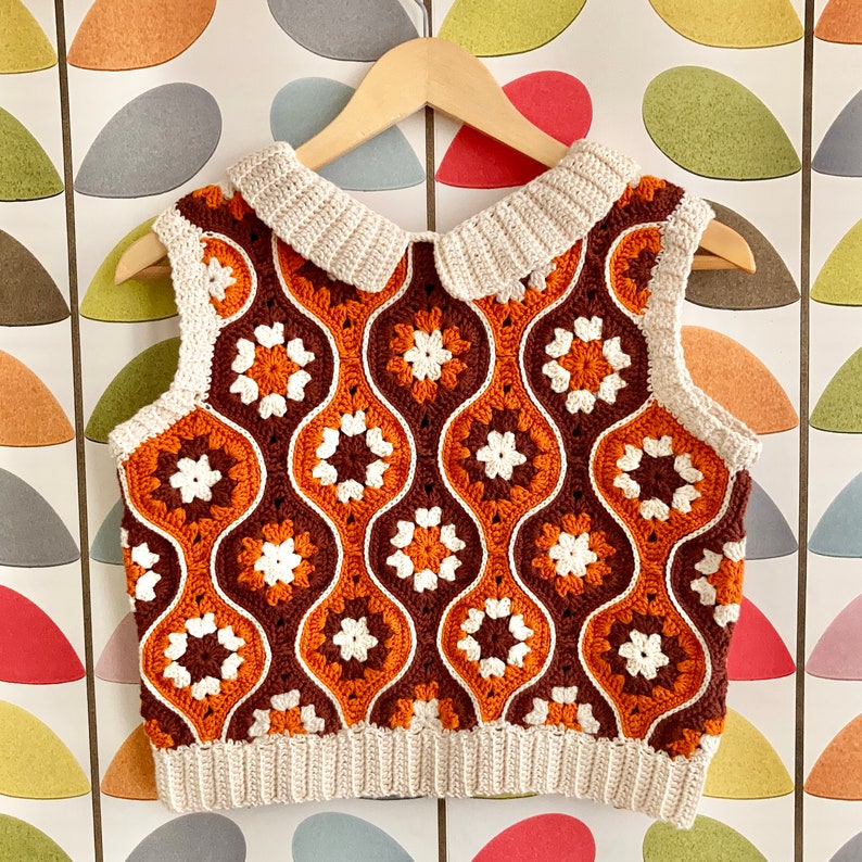 Pu&ograve; includere: Un gilet lavorato a uncinetto con un colletto bianco e un motivo geometrico marrone e bianco.