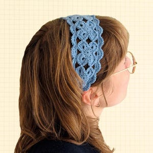 Peut inclure: Un bandeau bleu clair en crochet avec un motif floral. Le bandeau est porté sur la tête et est fait d'un fil doux et texturé. Le design présente des détails ajourés et un bord festonné, ajoutant une touche délicate à l'accessoire.