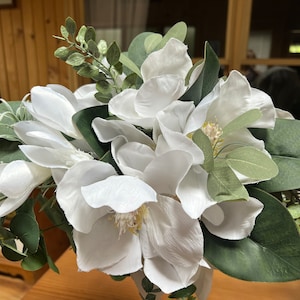 White bridal bouquet of magnolias and greenery