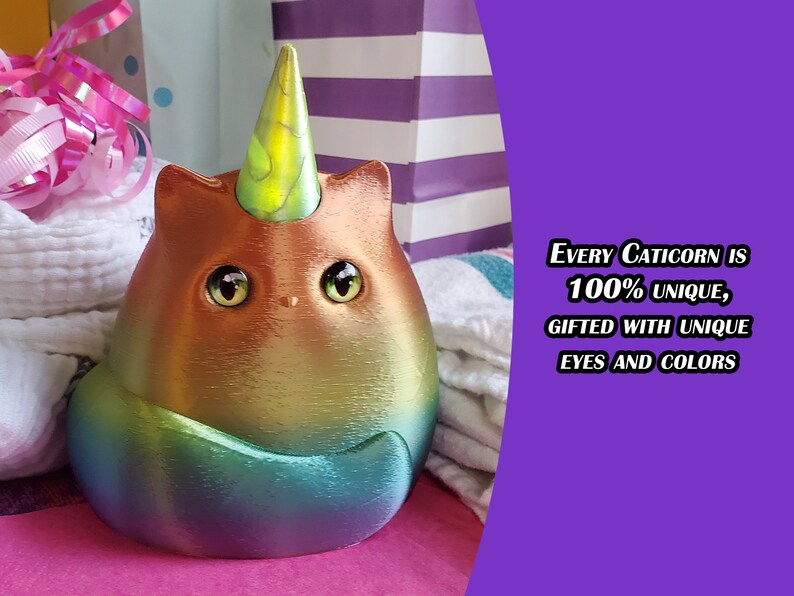 May include: A rainbow iridescent caticorn figurine with a yellow horn and large brown eyes. The text "EVERY Caticorn IS 100% UNIQUE, GIFTED WITH UNIQUE EYES AND COLORS" is visible in the background.