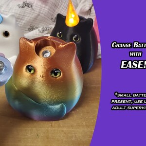 May include: Three colorful cat-shaped night lights with a unicorn, black cat, and rainbow cat design. The rainbow cat is shown with a battery compartment open, revealing a small battery. The text on the image reads "Change Batteries with Ease!! *Small Batteries Present, Use Under Adult Supervision*"
