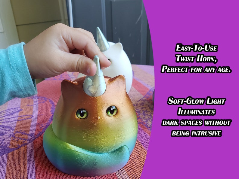 May include: A rainbow cat-shaped nightlight with a twistable horn that illuminates a room with a soft glow. The horn is being twisted by a hand.