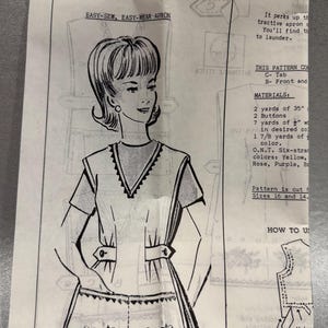 Puede incluir: Un sobre de patrón de costura vintage numerado 2133 para un delantal Easy-Sew, Easy-Wear. La ilustración muestra a una persona con un delantal de manga corta con cuello en V, pestañas laterales con botones y un dobladillo con estampado floral.