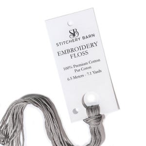 May include: A gray embroidery floss skein with a white label that reads "SB STITCHERY BARN EMBROIDERY FLOSS 100% Premium Cotton Pur Coton 6.5 Meters - 7.1 Yards"