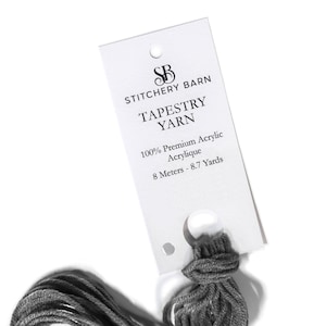 Peut inclure: Une pelote de fil à tapisserie grise avec une étiquette blanche qui indique "Stitchery Barn Tapestry Yarn 100% Premium Acrylic  Acrylique 8 Mètres - 8,7 Yards"
