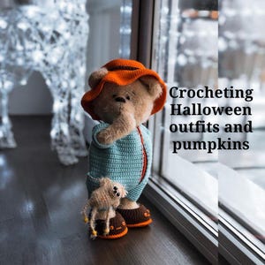 Könnte beinhalten: Ein gehäkelter Teddybär, der einen orangefarbenen Hut und ein blaues und weißes gehäkeltes Outfit trägt. Der Bär hält eine kleine gehäkelte Spinne. Der Text "Crocheting Halloween outfits and pumpkins" ist im Hintergrund sichtbar.