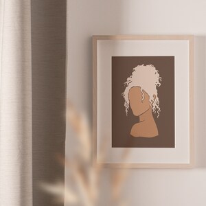 May include: A framed illustration of a person with blonde curly hair, a brown face, and a brown background.