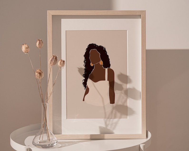 May include: A framed illustration of a woman with long, dark curly hair wearing a white tank top and gold earrings. The background is a light beige color.