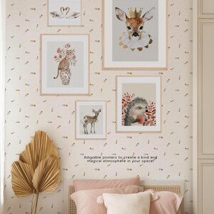 May include: Five framed animal illustrations with a white background and gold accents. The illustrations include a deer, a hedgehog, a swan, a cheetah, and a deer wearing a crown. The frames are all white with a gold border. The illustrations are all in a watercolor style. The text "Adorable posters to create a kind and magical atmosphere in your space!" is at the bottom of the image.