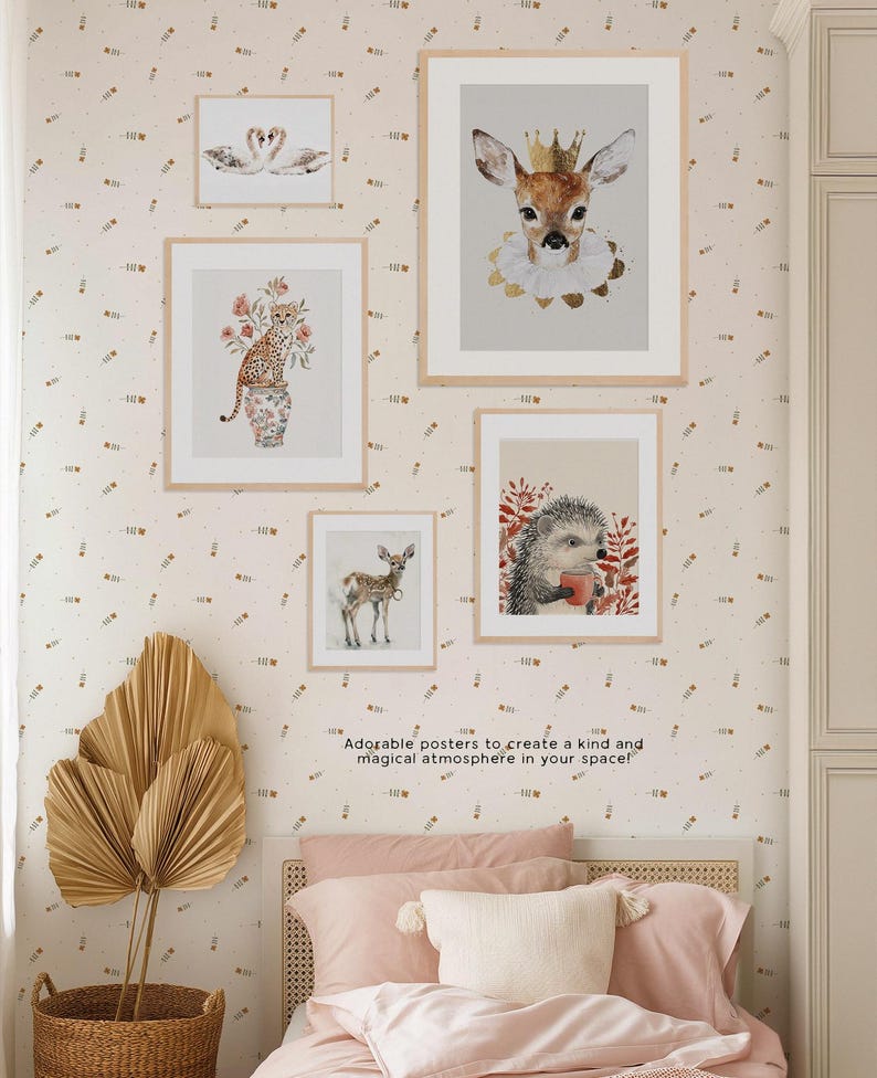 May include: Five framed animal illustrations with a white background and gold accents. The illustrations include a deer, a hedgehog, a swan, a cheetah, and a deer wearing a crown. The frames are all white with a gold border. The illustrations are all in a watercolor style. The text "Adorable posters to create a kind and magical atmosphere in your space!" is at the bottom of the image.