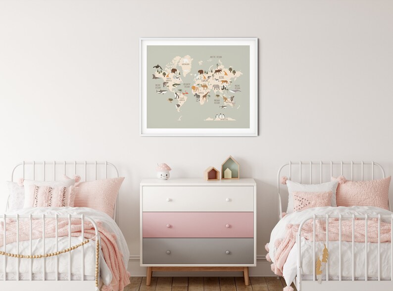 Peut inclure: Une carte du monde vert clair avec des illustrations d'animaux de diff&eacute;rents continents. La carte est encadr&eacute;e de blanc et accroch&eacute;e &agrave; un mur blanc. Deux lits jumeaux en m&eacute;tal blanc avec une literie rose sont de chaque c&ocirc;t&eacute; d'une commode &agrave; trois tiroirs avec un tiroir sup&eacute;rieur blanc, un tiroir central rose et un tiroir inf&eacute;rieur gris.
