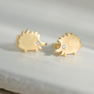 Playful hedgehog earrings in 8K yellow gold with cubic zirconia eyes – cute, golden, and irresistible.