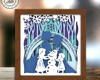 May include: A paper cut-out 3D diorama of a winter scene with two girls and a snowman. The girls are wearing blue and white dresses and the snowman is wearing a black top hat and a carrot nose. The scene is set in a snowy forest with a bridge in the background.
