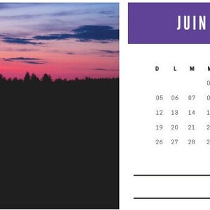 Puede incluir: Un calendario para junio de 2022 con un encabezado morado y una cuadrícula en blanco y negro. La imagen de fondo es una silueta oscura de árboles y un lago con un cielo de puesta de sol rosa y morado.