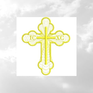 Op de afbeelding: Een geel geborduurd kruis met de letters "IC XC" op de bovenste en onderste armen. Het kruis bevindt zich op een witte achtergrond.