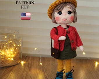 May include: Crochet pattern PDF for a doll wearing a red cardigan, green dress, yellow tights, and a brown purse. The doll has brown hair, a yellow hat, and blue shoes.