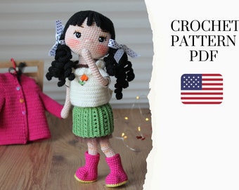May include: A handmade crochet doll with black hair, wearing a white top, green skirt, and pink boots. The doll has a sweet face and is adorned with white bows. The image includes a pink crochet jacket and text that reads "CROCHET PATTERN PDF".
