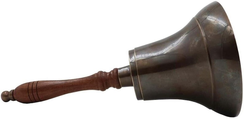Pu&ograve; includere: Una campana color bronzo con manico in legno. La campana ha una forma svasata e una superficie liscia e lucida. Il manico &egrave; di colore marrone scuro e ha una forma arrotondata con una piccola sfera all'estremit&agrave;. La campana viene probabilmente utilizzata per segnalare.