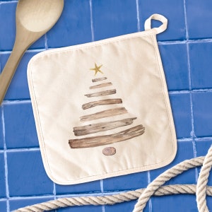 May include: Off-white square pot holder with a loop for hanging. The design features a Christmas tree made of wooden planks, topped with a gold starfish. A small stone is at the base of the tree.