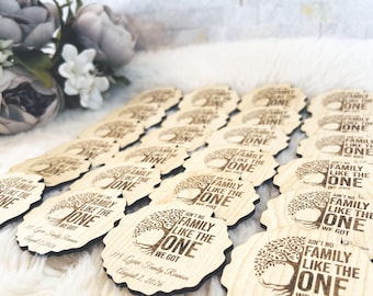 May include: A collection of round, scalloped-edge wooden ornaments featuring a laser-engraved tree design. Each piece displays the text 'AIN'T NO FAMILY LIKE THE ONE WE GOT', '115 Lynn Family Reunion', and the date 'August 2, 2026' in dark ink.