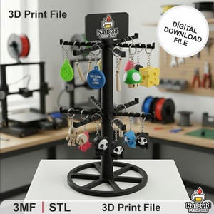 Może przedstawiać: Czarny stojak wystawowy z różnymi brelokami, w tym zieloną gruszką, grzybem i wzorami pandy. Stojak zawiera tekst "3D Print File" i "Digital Download File".