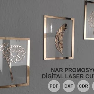 Pode incluir: Três peças de arte de parede emolduradas com molduras douradas e centros transparentes. A arte apresenta uma margarida, uma pena e uma folha. O texto "NAR PROMOSYON DIGITAL LASER CUT FILE" está abaixo.