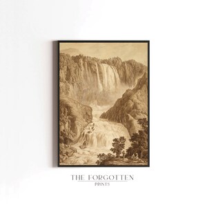 K&ouml;nnte beinhalten: Ein gerahmter Sepia-Druck eines Wasserfalls in einer Berglandschaft. Das Kunstwerk, in einem schwarzen Rahmen, hat detaillierte Schattierungen und eine klassische &Auml;sthetik. Der Druck enth&auml;lt den Text "THE FORGOTTEN PRINTS" am unteren Rand.