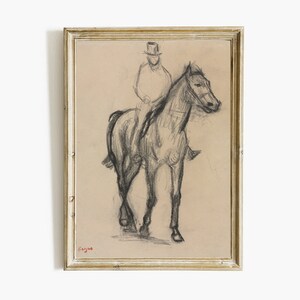 K&ouml;nnte beinhalten: Gerahmte Kohlezeichnung eines Reiters auf einem Pferd. Das Kunstwerk zeigt eine Person mit Zylinder, die auf einem Pferd sitzt. Die Zeichnung befindet sich auf beigem Hintergrund, in einem goldfarbenen Rahmen. Die Signatur des K&uuml;nstlers befindet sich unten links.