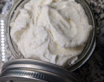 May include: A white creamy substance in a glass jar with a silver lid. The jar is sitting on a gray and white speckled surface.