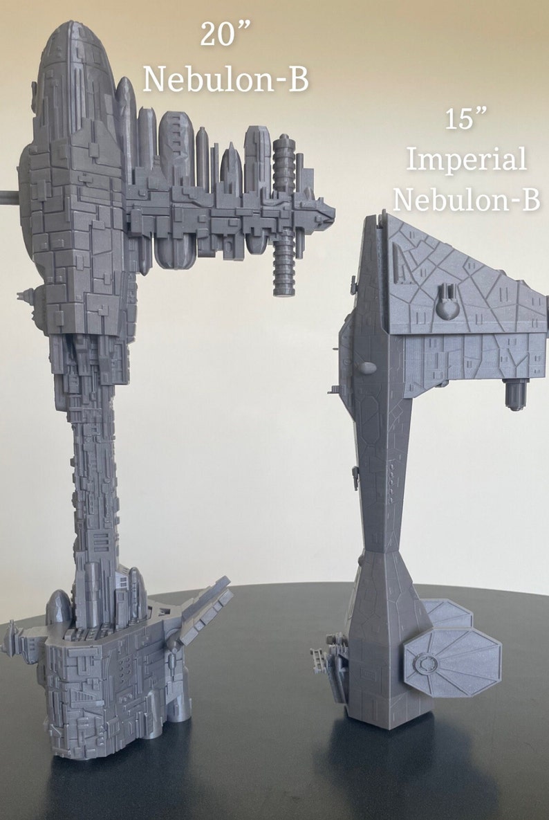 May include: Two grey 3D printed models of the Nebulon-B starship from Star Wars. The larger model is 20 inches tall and labelled "20" Nebulon-B". The smaller model is 15 inches tall and labelled "15" Imperial Nebulon-B".