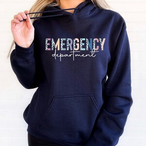 May include: Navy blue hooded sweatshirt with the text "EMERGENCY department" in colorful letters with a leopard print pattern.