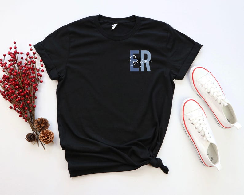 May include: Black t-shirt with a blue and white ombre design that says "ER Sofia" on the front.