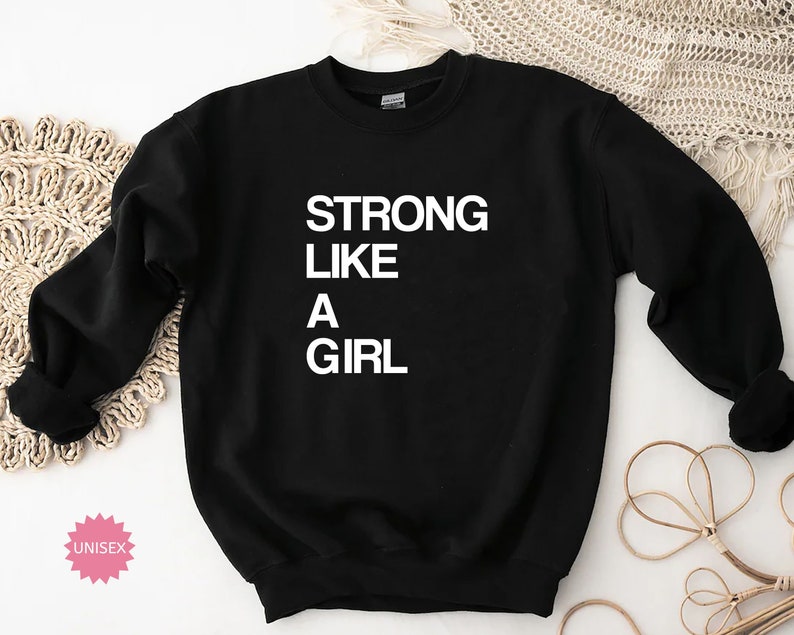 May include: Black sweatshirt with the text "STRONG LIKE A GIRL" in white.